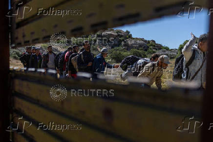 Asylum seeking migrants line up to enter the United States from Tecate, Mexico