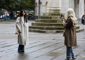 A woman takes a photo of her friend in Manchester