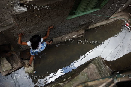 Criana tenta passar por uma viela em