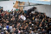 FILE PHOTO: Palestinians gather to receive aid outside an UNRWA warehouse in Gaza City