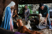 A man arranges a sheep statue to prepare for the Christmas mass at the Jakarta Cathedral in Jakarta