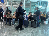 People wait for their flight after rainstorm hit Dubai, causing delays at the Dubai International Airport