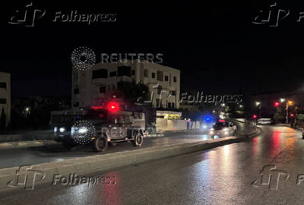 Police vehicles on a street near the Israeli embassy in Amman