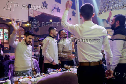 People gather on Christmas day at a restaurant in Damascus