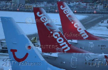 Snow is seen on the tails of aircraft after overnight snowfall caused the temporary closure of Manchester Airport in Manchester