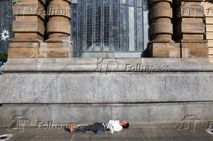 Pessoa em situao de rua dorme ao lado do Theatro Municipal, na regio central de SP
