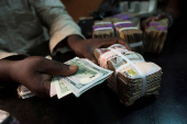 FILE PHOTO: A trader changes dollars with naira at a currency exchange store in Lagos