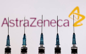 FILE PHOTO: Syringes with needles are seen in front of a displayed AstraZeneca logo in this illustration taken