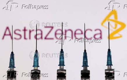 FILE PHOTO: Syringes with needles are seen in front of a displayed AstraZeneca logo in this illustration taken