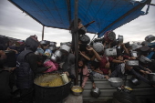 Displaced Palestinians collect donated food in Khan Yunis, southern Gaza