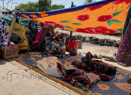 People take refuge along an expressway after relief camps reached maximum capacity in Maiduguri