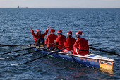 People in Santa Claus costumes row off the seafront of Thessaloniki