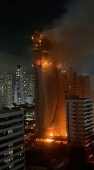 Smoke and flames rise from a high rise building on fire in Torre