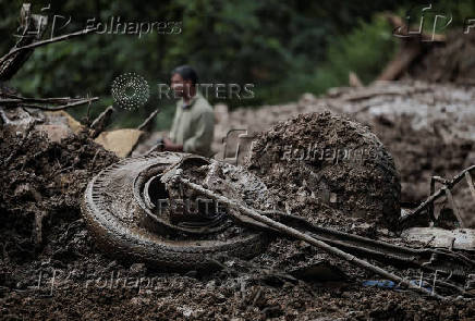 Rescue personnel work to retrieve the bodies of victims from a landslide triggered by heavy rainfall, in Dhading