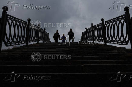 People walk on bridge, on a rainy day in Moscow