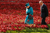 FILE PHOTO: Britain's Queen Elizabeth and Prince Philip walk through a field of ceramic poppies that form part of the art installation 