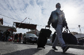 A man with his bags walks into Lebanon after Syrian rebels announced that they have ousted President Bashar al-Assad, at Masnaa Border Crossing