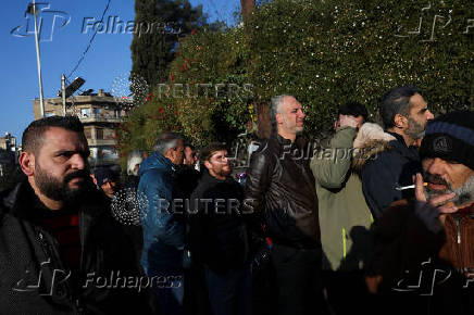 Former members of Syria's Bashar Al Assad's security forces wait to register for the identification and reconciliation process, in Damascus