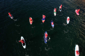 Members of the ThesSUP team wearing Santa Claus costumes paddle off the seafront of Thessaloniki