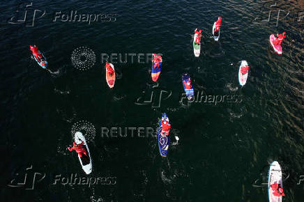 Members of the ThesSUP team wearing Santa Claus costumes paddle off the seafront of Thessaloniki