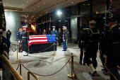 Mourners view the changing of guard of the joint services military honor guard as the casket of former President Jimmy Carter as he lies in repose at the Jimmy Carter Presidential Library and Museum in Atlanta