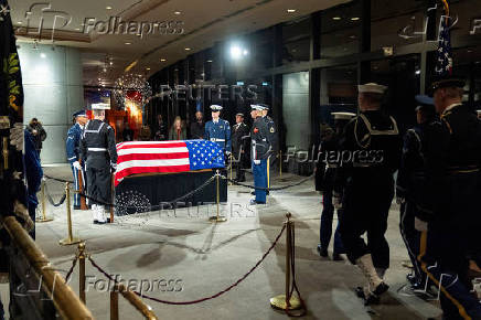 Mourners view the changing of guard of the joint services military honor guard as the casket of former President Jimmy Carter as he lies in repose at the Jimmy Carter Presidential Library and Museum in Atlanta