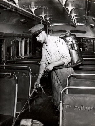 Funcionrio com pulverizador, durante desinfeco dos nibus em So Paulo (1957)