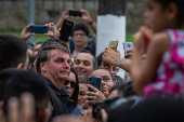O presidente Jair Bolsonaro cumprimenta populares, em Guaruj (SP)