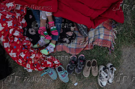 Migrants sleep along international border between Mexico and United States