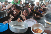 Palestinians gather to receive food cooked by a charity kitchen, amid the Israel-Hamas conflict, in the northern Gaza Strip