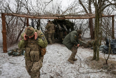 FILE PHOTO: Ukrainian servicemen fire a howitzer towards Russian troops near the frontline town of Pokrovsk