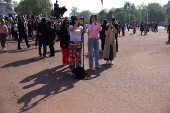 Tourists take pictures of Buckingham palace in London
