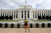 FILE PHOTO: A jogger runs past the Federal Reserve building in Washington, DC