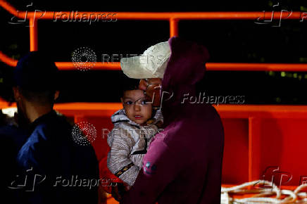 Migrants wait to disembark from a Spanish coast guard vessel, in the port of Arguineguin, on the island of Gran Canaria