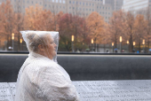 A woman looks ahead at the 9/11 Memorial on a rainy day in New York