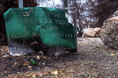 A burnt road sign noting a closed military area is seen at the side of a road near the Israeli border with Lebanon amid cross-border hostilities between Hezbollah and Israel