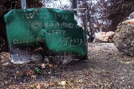 A burnt road sign noting a closed military area is seen at the side of a road near the Israeli border with Lebanon amid cross-border hostilities between Hezbollah and Israel