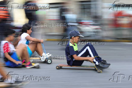 Government supporters participate in a traditional street race with wooden makeshift carts called 