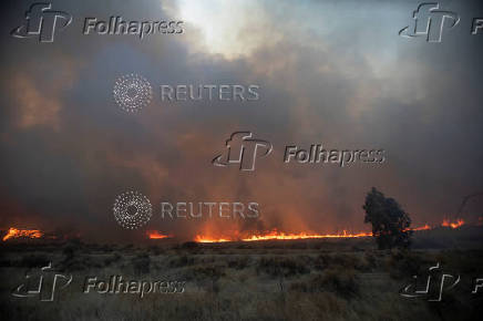 Firefighters and aircraft battle the Hughes Fire near Santa Clarita