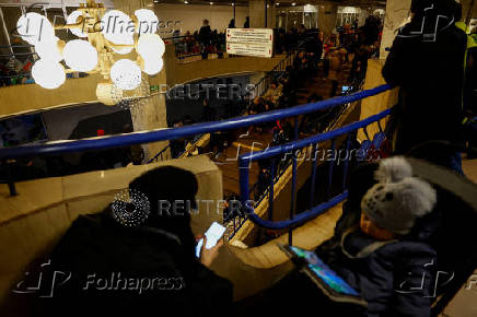 People take shelter inside a metro station during a Russian military strike, in Kyiv