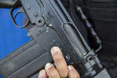 Soldado da PM do Rio mostra arma que usa e que foi doada pelo Exrcito 