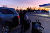 FILE PHOTO: People wait for transport to cross into Canada at Roxham Road, in Plattsburgh