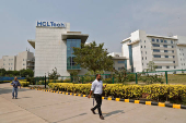 Employees of HCLTech walk inside the office premises on outskirts of Lucknow