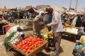 A man buys vegetables from a local vendor during the month of Ramadan in the city of Omdurman
