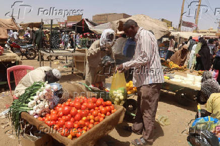 A man buys vegetables from a local vendor during the month of Ramadan in the city of Omdurman