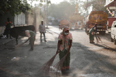 Workers from the Bruhat Bengaluru Mahanagara Palike (BBMP) clean the area outside a polling station a day ahead of the second phase of India's general election, in Bengaluru