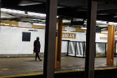 FILE PHOTO: A woman waits for a subway to arrive at the Nostrand Avenue station subway platform in the Brooklyn borough of New York City