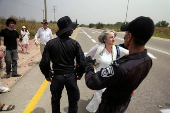 Israeli police stop a protestor during a demonstration by Israeli and American Rabbis as they block a road while they gather to symbolically bring food to Gaza, near Erez crossing