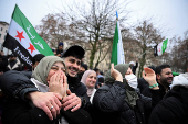 People gather on the streets, after Syrian rebels announced that they have ousted President Bashar al-Assad, in Berlin