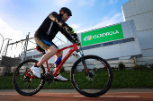 A cyclist passes an Iberdrola electrical substation in Santurce, port of Bilbao